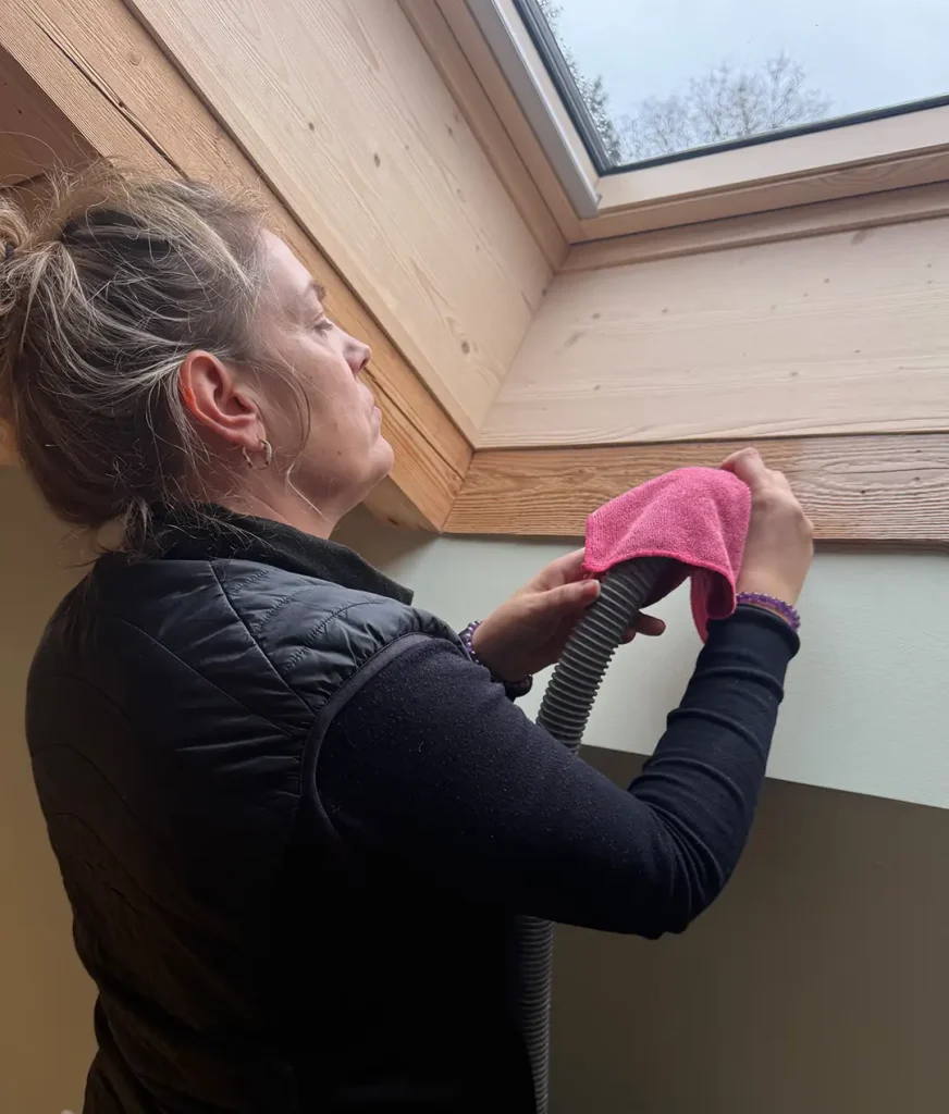 Gebäudereinigung durch VIOMI bei der Reinigung eines Dachfensters im Innenbereich
